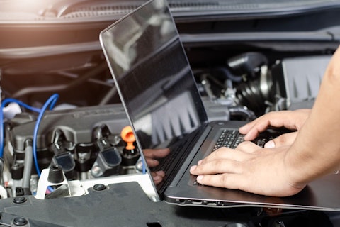 Detail of a mechanic using electrnoic diagnostic equipment to tune a car